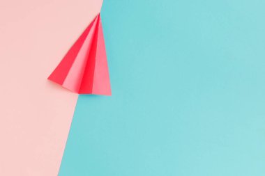 Pastel pembe ve mavi arka plan üzerinde kırmızı kağıt uçak. En az düz okul kavramı yatıyordu