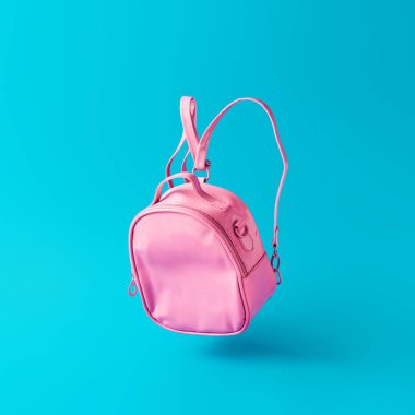 Pastel pembe okul çantası gökyüzü mavi arka plan, gerçeküstü modern natürmort yüzer. Geri okul en az kavramı 