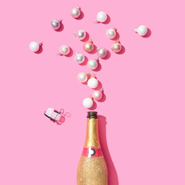 Gyllene Glittrande Champagneflaska Med Grannlåt Juldekoration Rosa Bakgrund Minimal Party — Stockfoto