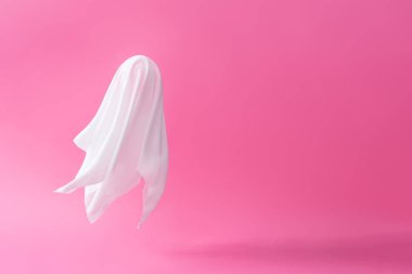 Pastel pembe arka plan beyaz hayalet sayfa kostüm. En az Cadılar Bayramı korkutucu kavramı.