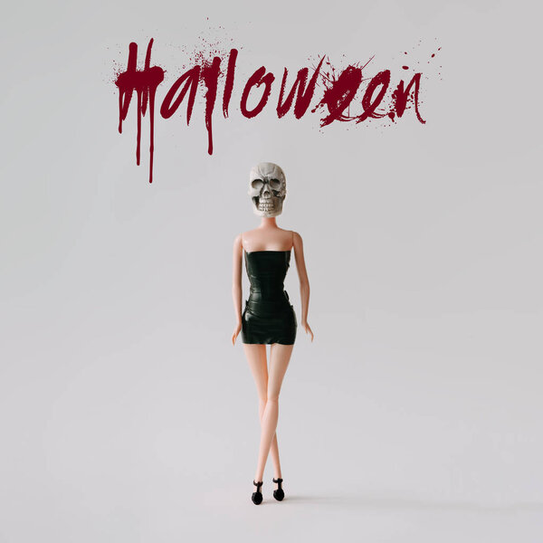 Girl doll with horror skull costume and text Halloween. Minimal holiday concept.