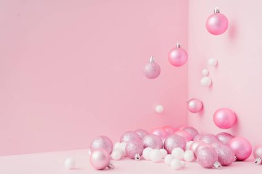 Pastel pembe üzerinde baubles ile yaratıcı Noel tasarım. Yeni yıl partisi konsepti