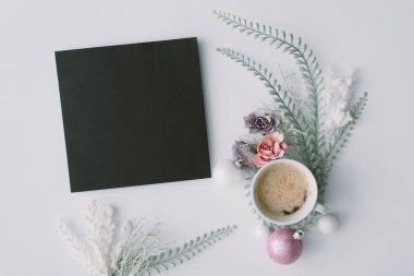 Çiçekler ve kahve fincanı tablo, üstten görünüm üzerinde kağıt kart ile yaratıcı kış doğal kompozisyonu. 