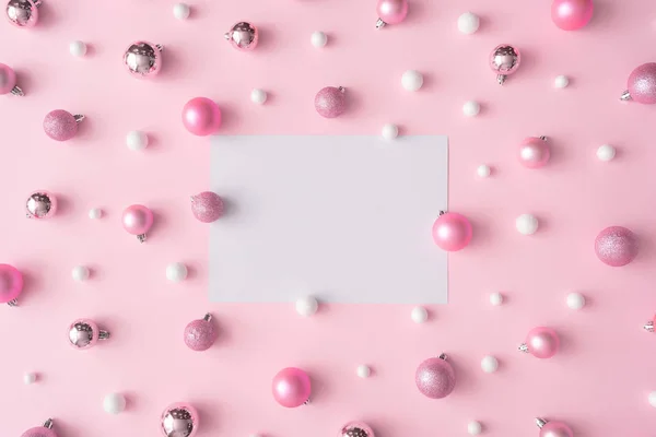 センターでの紙のカードやピンクのパステル カラーの背景にボールの創造的なクリスマスの構成 新しい年の概念 — ストック写真