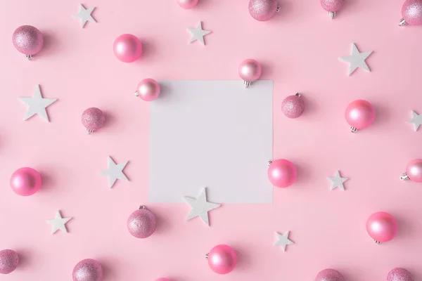 ピンクのパステル カラーの背景に白い星でセンターとボール紙カードの創造的なクリスマスの構成 新しい年の概念 — ストック写真