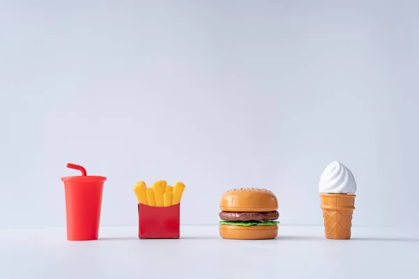 Fast food items on pastel grey background. Junk food minimal concept.