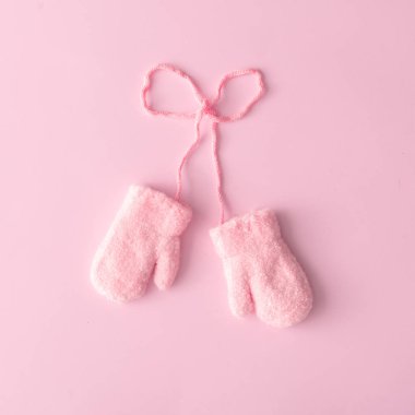 Pembe yün eldiven pastel bir arka plana dayanır. En az kış konsepti 