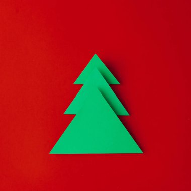 En az kağıt sanat Noel ağacı kırmızı zemin üzerine. Yeni yıl kavramı.