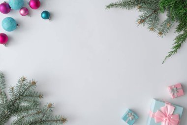 Renkli Noel dekoratif topları ve hediye beyaz zemin üzerine yeşil çam dalları ile yapılmış yaratıcı düzeni. En az kış tatil kavramı 