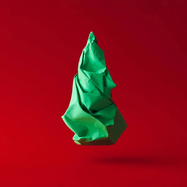 最小限の新年の概念 赤の背景に緑の崩れた紙のクリスマス ツリー — ストック写真