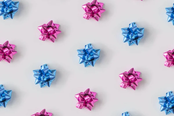 プラスチックのピンクとブルーの装飾クリスマス ギフトの最小限のコンポジションの背景の弓します 新しい年の概念 — ストック写真