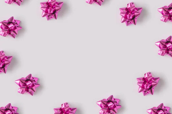 プラスチック製の装飾的なクリスマス ギフト ピンクの光の背景 新年の概念に弓します — ストック写真