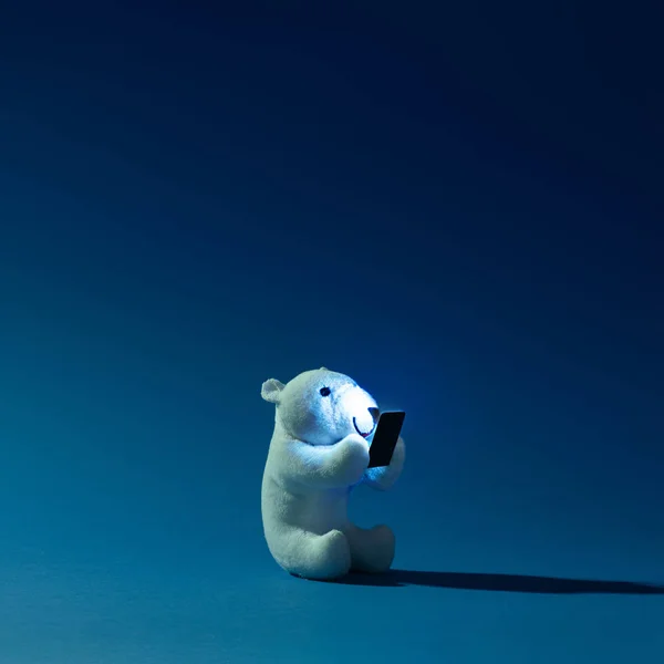 Lední Medvěd Toy Mobilním Telefonem Noční Modré Pozadí Zimní Koncept — Stock fotografie