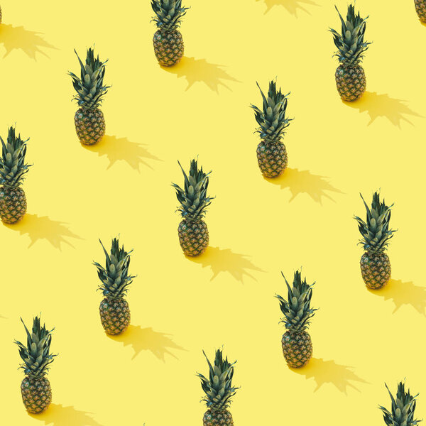 Tropical pineapple pattern on pastel yellow background. Minimal summer fruit concept 