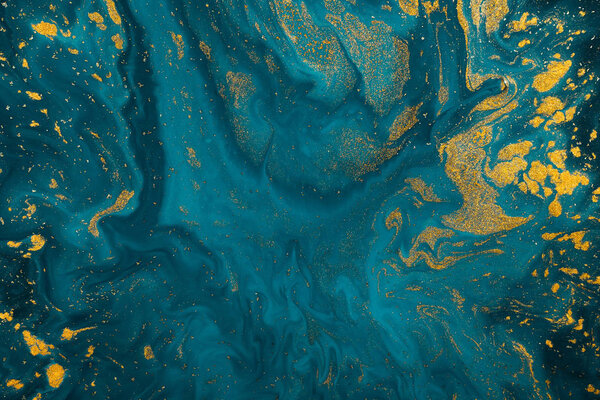 Abstract blue paint background with golden glitter powder 