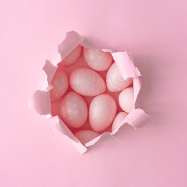 Pastel kağıt delikte pembe Paskalya yumurtası. Minimal Paskalya arka plan kompozisyon 