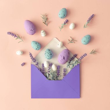 Bahar çiçekleri ile yapılmış yaratıcı düzeni ve pastel pembe arka plan üzerinde Paskalya yumurtası ve Kağıt zarf ile yaprakları. Minimal tatil bileşimi 