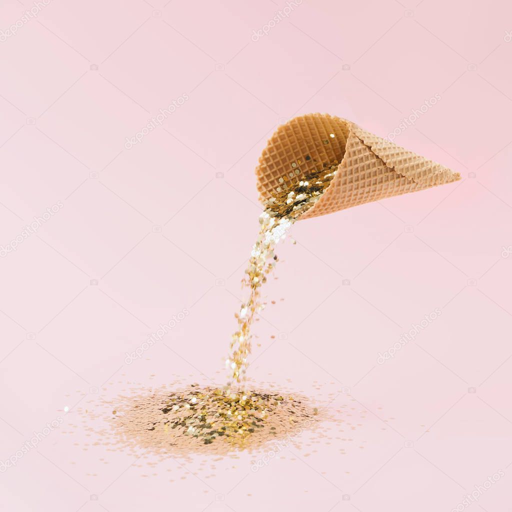 Ice cream with gold glitter on pastel pink background . Minimal summer food concept 