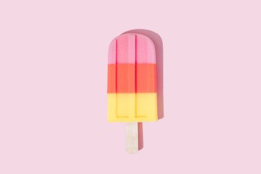 Pastel pembe arka plan üzerinde renkli Dondurma popsicle. Minimal yaz konsepti 