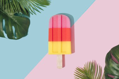 Kağıt duotone arka plan üzerinde tropikal palmiye yaprakları ile pastel pembe renkte dondurma popsicle . Minimal yaz konsepti 