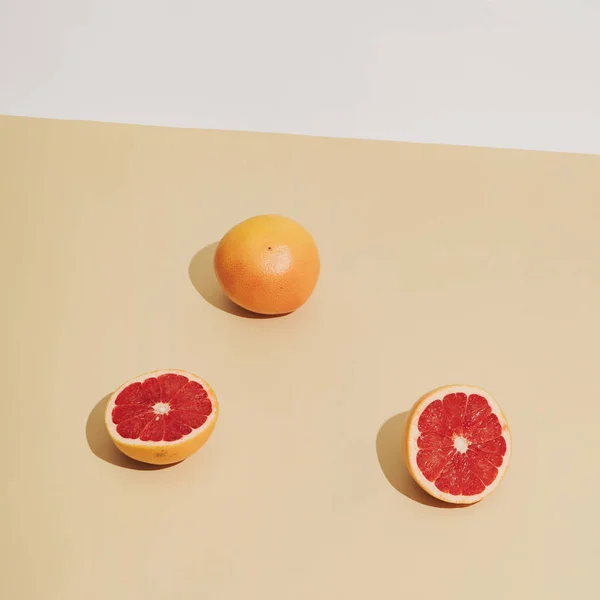 砂色の背景に影を持つグレープフルーツの最小限の日光フルーツの組成 夏のクリエイティブコンセプト — ストック写真