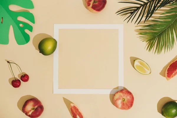 最少的阳光水果组成与阴影和白色纸框与棕榈叶在沙色背景 夏季创意理念 — 图库照片
