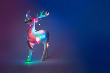 mor arka plan, Yeni yıl kavramı üzerinde Noel ışıkları dekorasyon ile oyuncak geyik 