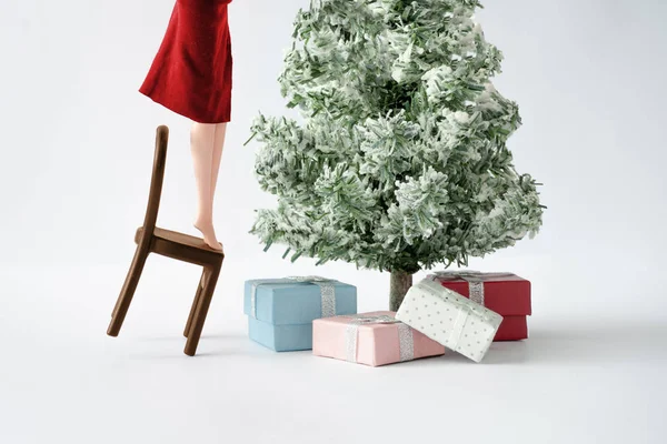 クリスマスツリーを飾る若い女の子の人形 クリエイティブなホリデーコンセプトの背景 — ストック写真