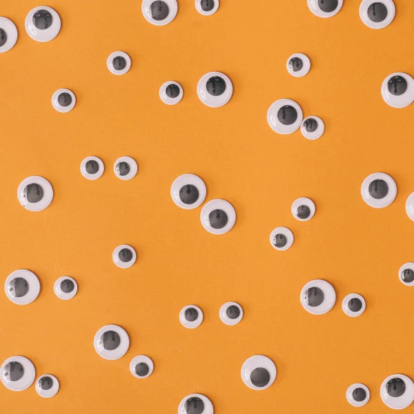 Halloween monster eyes on orange background. Funny holiday concept