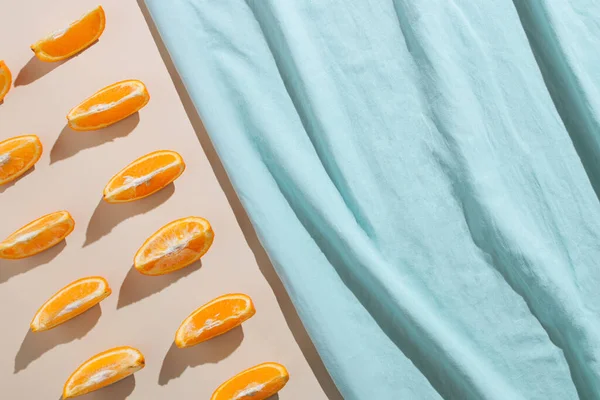 Summer scene with fresh slices of orange and blue beach towel. Minimal aesthetic.