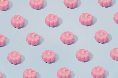Pastel pembe ve mavi renkte sonbahar deseni. Cadılar Bayramı balkabakları arka planda.