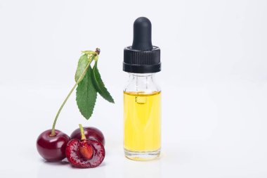 yanındaki beyaz zemin üzerine kırmızı dut kiraz lezzet bir şişe sıvı
