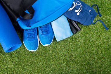 Eğitim, çantaya, çim zemin üzerine mavi spor giyim kümesi