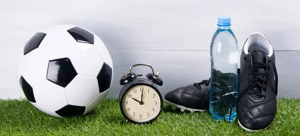 Μπάλα Ποδοσφαίρου Μπότες Μπουκάλι Νερό Ρολόι Συναγερμών Στέκεται Στο Γρασίδι — Φωτογραφία Αρχείου