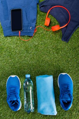 mavi spor giyim, bir şişe su ve aksesuarlar, fitness, üst üste çim arka planı düzenlenir