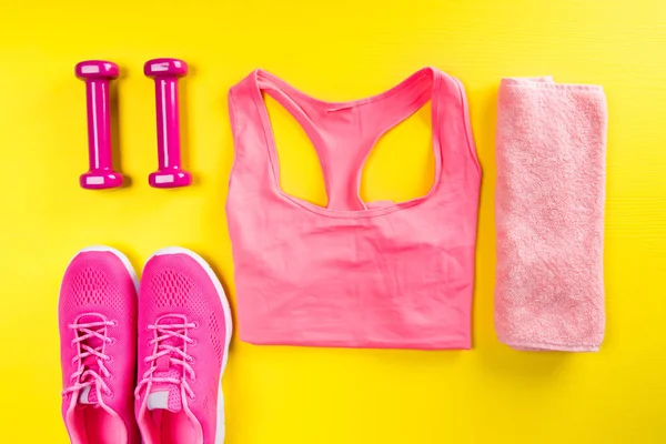 pink sportswear and accessories for fitness, on a yellow background