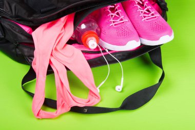 pembe spor ve fitness, açık yeşil arka planı üzerinde bir çanta için aksesuarlar