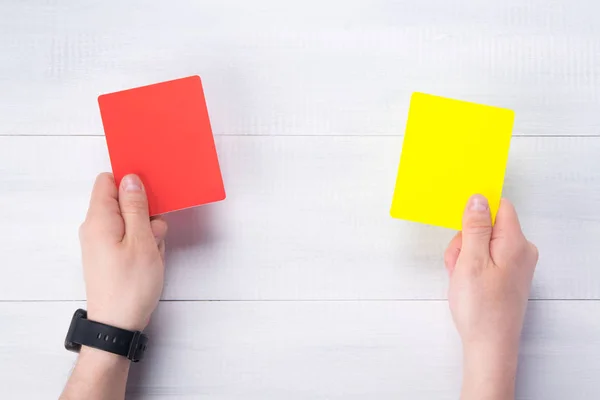 two penalty cards in the judge's hands, on a gray background