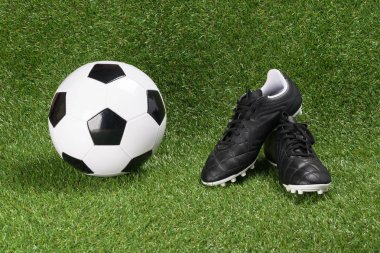 Futbol topu ve yeşil bir yapay çim bot