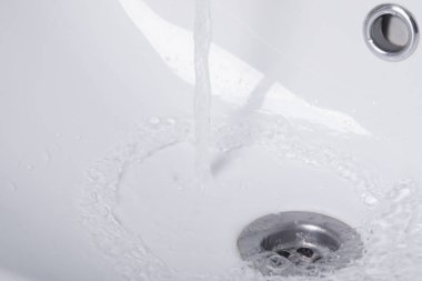 sıcak su musluk, beyaz bir lavabo içine akar.