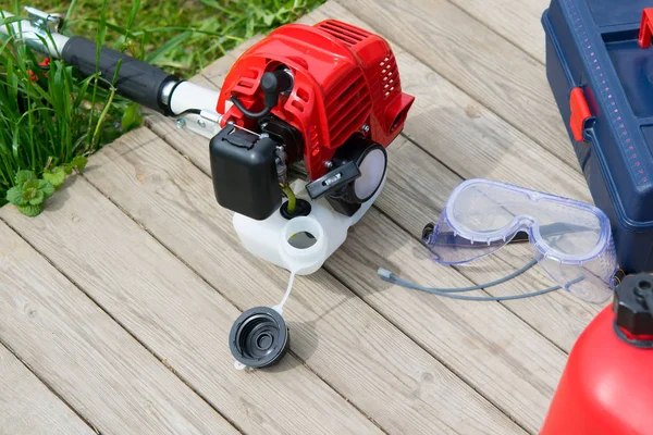 ve yeniden yakıt biçme için çekmece ve koruyucu gözlük öğelerin bir ahşap arka plan üzerinde yalan