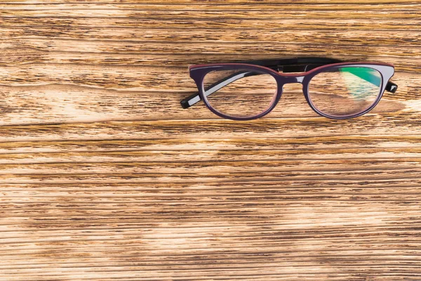 glasses for correcting vision lie on a dark wooden background