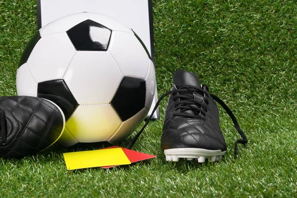 topu ve futbol hakem, yeşil çim üzerinde bir sarı ve kırmızı kart ile için ayakkabı