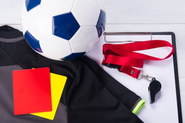 futbol topu, spor t-shirt, tablet, iki ceza kartı ve bir düdük kırmızı şerit üzerinde gri bir arka plan üzerine yargıç için kayıt