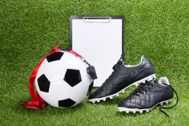 futbol topu, siyah çizmeler, bir yargıç ve bir tablet için çim bir arka plan üzerinde yazılı kırmızı şerit ıslığı