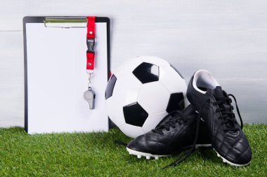 futbol topu, çizme ve yazma, bir yargıç için bir tablet ıslığı gri bir arka plan üzerinde çim üzerinde yalan