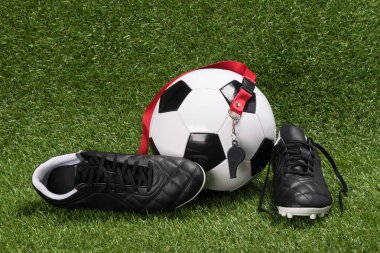 Ayakkabı ve futbol oynamak için top yeşil çim üzerinde yalan