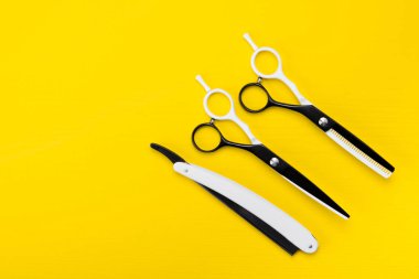 parlak sarı bir arka plan üzerinde orada makas ve saç kısaltmak ve bir saç modeli oluşturmak için bir tarak.