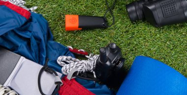 Açık havada, çadır, termos bardağa, bir balta ve dürbün öğeler kümesi.