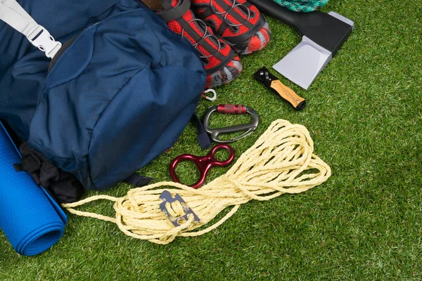Shoes and objects for survival in adventure travel, on the green grass